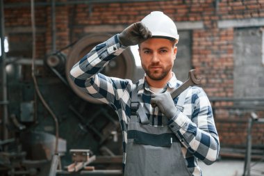 Gri üniformalı ve beyaz şapkalı. Fabrika erkek işçisi içeride..