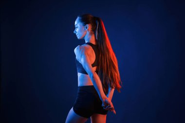 Dikiz aynası. Güzel kaslı kadın stüdyoda neon ışıklı..