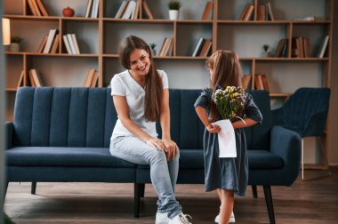 Anneler Günü kavramı. Hediye vermek. Kızıyla birlikte genç bir kadın dairede..