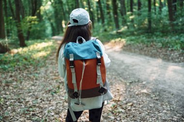Sırt çantasıyla. Kız yaz günü ormanda yeni yerler keşfediyor..