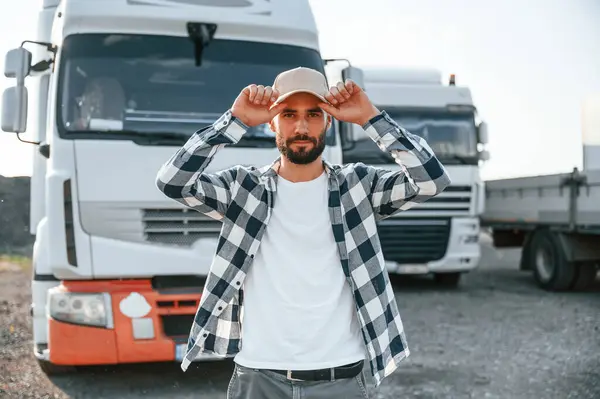 stock image Wearing cap. Young truck driver is with his vehicle at daytime.