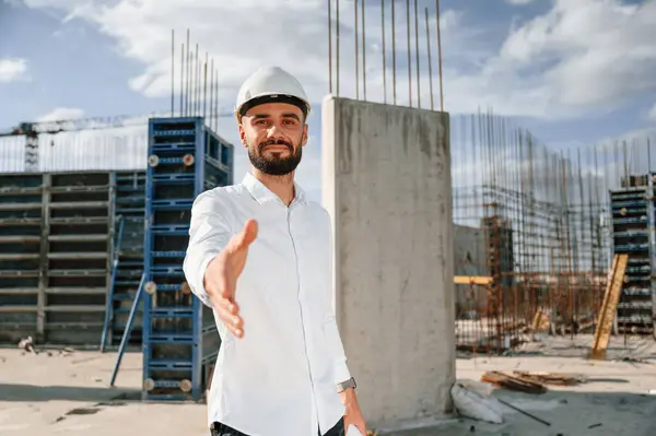 stock image Engineer extends his hand. Man in uniform is working on the construction site.