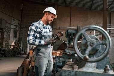 Metal işleme. Üniformalı fabrika çalışanı içeride..