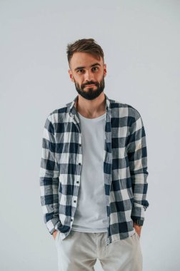 Kareli bir gömlekle. Yakışıklı adam stüdyoda mavi arka planda..