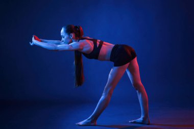 Spor egzersizleri yapıyorum. Güzel kaslı kadın stüdyoda neon ışıklı..