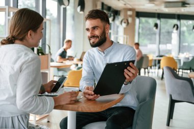 İşadamı, kafede dizüstü bilgisayarla otururken bir kadınla çalışıyor..