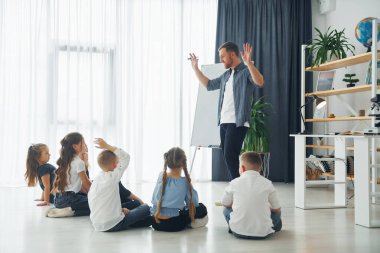 Beyaz tahtayı kullanarak. Okulda öğretmenle birlikte bir grup çocuk öğrenci..