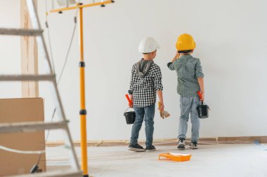 Neşeli çocuklar. İki çocuk ev odasında duvar boyuyor..