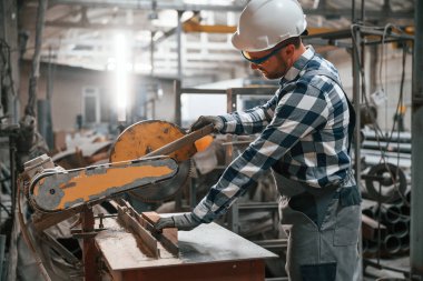 İşletim makinesiyle çalışıyor. Üniformalı fabrika işçisi içeride..