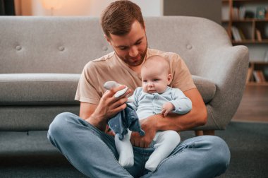Yumuşak oyuncaklar kullanarak oynamak. Yeni doğmuş bebeğiyle baba içeride. Bekar baba kavramı.