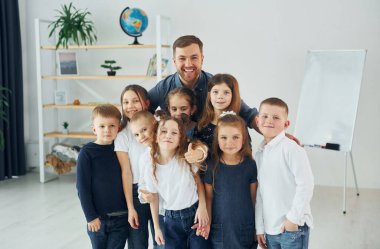 Birlikte duruyoruz. Okulda öğretmenle birlikte bir grup çocuk öğrenci..