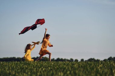 Uçurtmayla koşmak. İki kız yazın açık havada eğleniyor..
