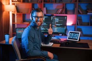 Başparmağımı gösteriyorum. Profesyonel programcı içeride çalışıyor. Neon ışıkları.