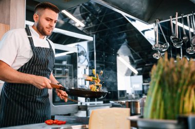 Lezzetli salata yapmaya odaklanmış. Şef mutfakta yemek hazırlıyor..