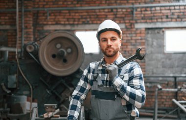 Gri üniformalı ve beyaz şapkalı. Fabrika erkek işçisi içeride..