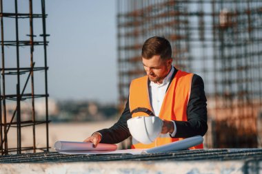 Adam gündüz vakti şantiyede çalışıyor. Planı okuyorum..