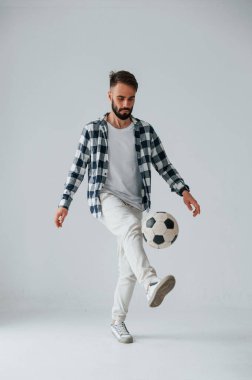 Futbol oynuyordum. Yakışıklı adam stüdyoda beyaz arka plana karşı..