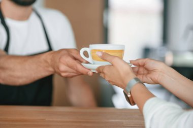 Manzarayı kapat. Müşteri kahveciden siparişini alıyor..