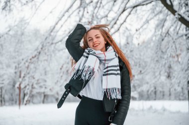 Sıcak eşarbın içinde. Güzel genç bir kadın kış ormanında dışarıda..