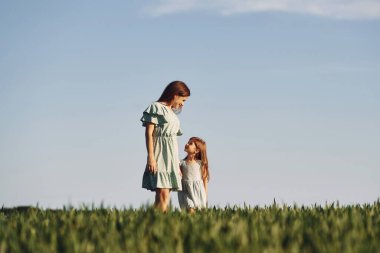 El ele tutuşarak. Anne ve kızı yazın açık havada eğleniyorlar..