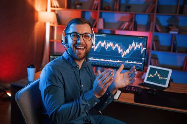 Alkışlar, başarı anlayışı. Hisse senedi tüccarı kapalı alanda bilgisayar başında çalışıyor. Değişim ve para kavramı.