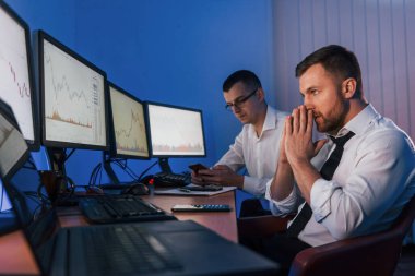 Stresli bir iş. İki borsa simsarı ofislerinde değişim teknolojisiyle monitörlerde..