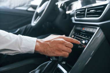 Beyaz elbiseli genç adam araba galerisinde..