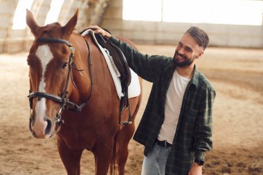Eyere dokunuyorum. Atlı genç adam hangarda..