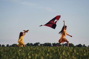 Uçurtmayla koşmak. İki kız yazın açık havada eğleniyor..
