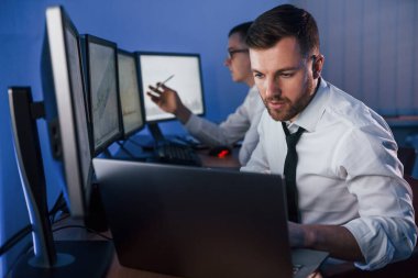 Resmi kıyafetlerle. Ofiste değişim teknolojisiyle çalışan iki borsacı..