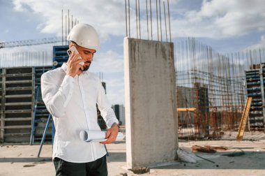 Telefonda sohbet ediyorduk. Üniformalı adam inşaat alanında çalışıyor..