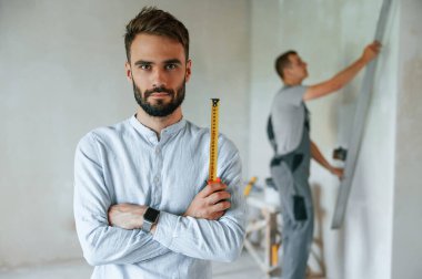 İki adam dairede birlikte tamirat yapıyor..