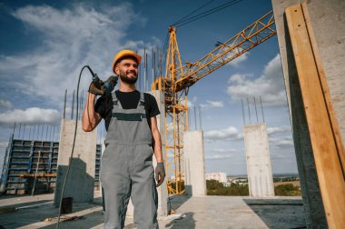 Durma ve tutma talimi. Üniformalı adam inşaat alanında çalışıyor..