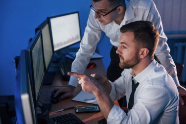 Resmi kıyafetlerle. Ofiste değişim teknolojisiyle çalışan iki borsacı..