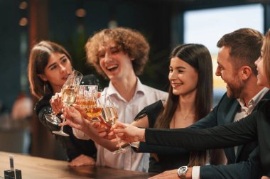 Birlikte oturuyoruz. Bir grup şık giyinmiş insan restoranda kutlama yapıyor..