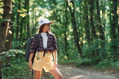Durup doğaya bakmak. Kız yaz günü ormanda yeni yerler keşfediyor..