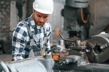 İşletim makinesiyle çalışıyor. Üniformalı fabrika işçisi içeride..
