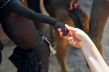 Dokunaklı eller, selamlaşma hareketi. Turistler Afrikalı çocuklarla Namibya 'da.