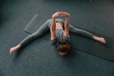 Üst Manzara. Yoga elbiseli genç bir kadın içeride spor yapıyor..