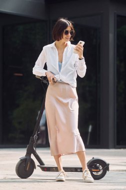 Telefonla. Güzel, genç bir bayan dışarıda motosikletiyle bekliyor..