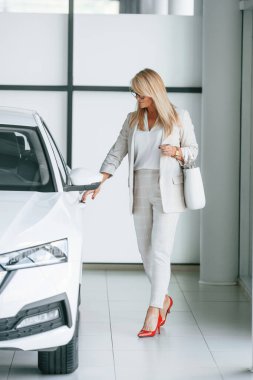 Otomobile gidiyorum. Beyaz elbiseli kadın araba galerisinde..