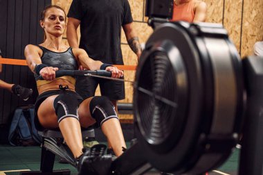 Ön manzara. Spor salonunda kürek çeken sporcu bir kadın..