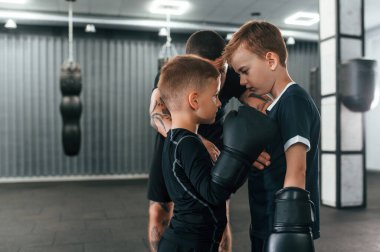 Antrenman için hazırlanıyorum. Genç dövmeli koç çocuklara boks teknikleri öğretiyor..