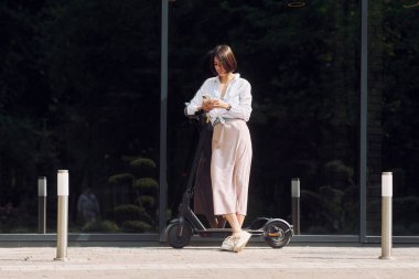 Telefonla. Güzel, genç bir bayan dışarıda motosikletiyle bekliyor..