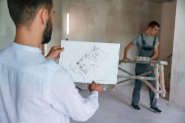 Bir plana göre çalışıyoruz. İki adam dairede birlikte tamirat yapıyor..