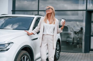 Kahve molası. Beyaz elbiseli kadın araba galerisinde..