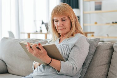 Kitabı okuyordum. Kızıl saçlı yaşlı kadın evde yalnız..