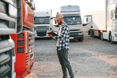 Bir bardak içki ve not defteriyle. Genç kamyon şoförü gündüz vakti aracıyla geliyor..