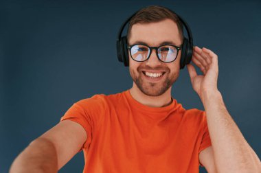 Yakışıklı adam stüdyoda mavi arka planda..