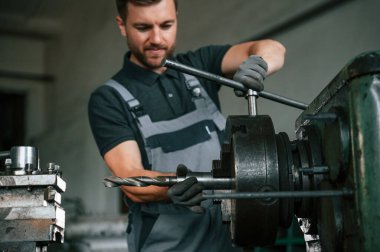 El işi ayrıntıları. Üniformalı adam iş yerinde tarım tekniğinin detaylarını geliştiriyor..